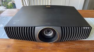 Proiectorul BenQ W5800 pentru cinema acasă, văzut din față cu un unghi ușor ridicat