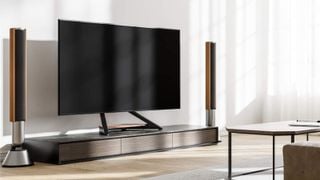 Suportul TV Fitueyes Eiffel prezentat ținând un televizor mare într-un living de lux
