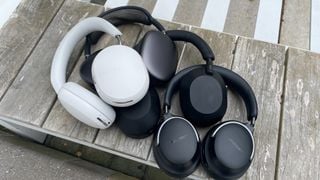 Sonos Ace, Sony WH-1000XM5, Apple AirPods Max și Bose QC Ultra Headphones împreună pe o bancă