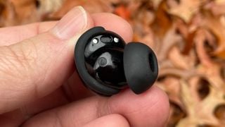 Căști Bose QuietComfort Earbuds wireless cu o singură cască ținută în mână