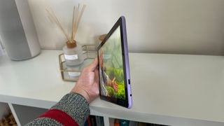 Tableta Amazon Fire HD 10 (2023) unghi lateral în fața unui raft alb