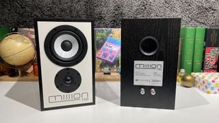 Boxele stereo Mission 750 în fața unui raft aglomerat, cu o boxă orientată spre spate
