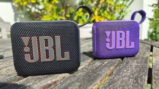 Boxe Bluetooth JBL Go 4 pe o masă de lemn arătând logo-ul JBL