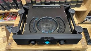 Amplificator Chord Ultima Integrated din unghi ușor superior pe raft hi-fi din lemn
