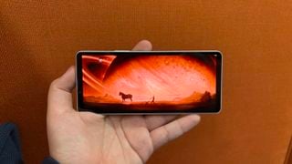 Sony Xperia 10 VI în mână cu o scenă din Rebel Moon pe Netflix pe ecran