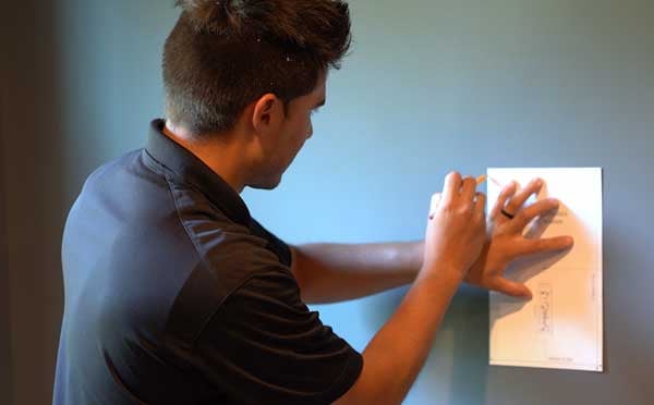 Montator trasând șablonul boxei înglobate în perete