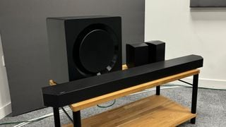 Toate componentele de sistem soundbar Samsung HW-Q990D pe bancă TV din lemn