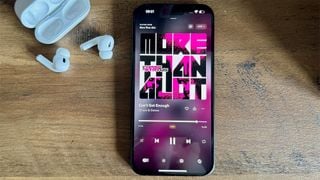 Smartphone Apple iPhone 15 Plus pe suprafață de lemn cu AirPods