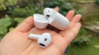Căști wireless Apple AirPods 4 cu ANC ținute în palma mâinii