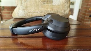 Sony ULT Wear căști over-ear vedere laterală pe masă de lemn