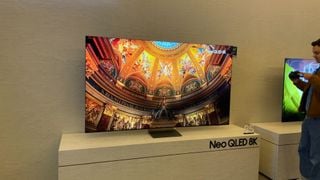 Televizor Samsung QN900D 8K QLED de 85 inch pe suportul său pe podeaua CES