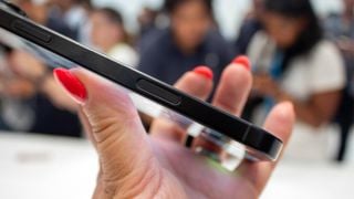 iPhone 16 Plus smartphone ținut în mână văzut din lateral