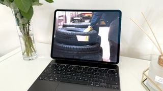 Tableta Apple iPad Pro de 13 inchi M4 pe suprafață de lemn alb cu anvelope pe ecran