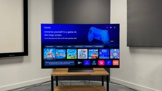 LG C4 de 65 de inci pe un raft de lemn cu secțiunea de gaming a sistemului de operare pe ecran