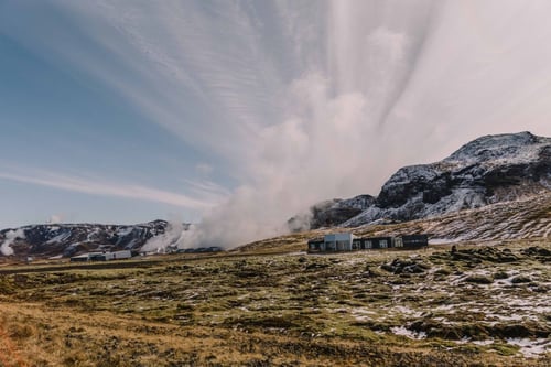 a landscape with a building and mountains