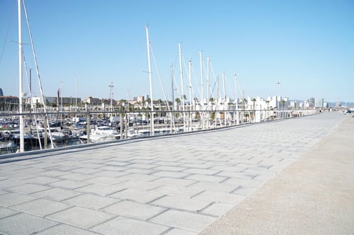 a walkway with sailboats in the background