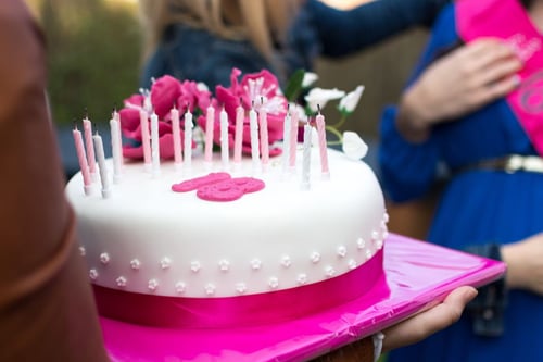 a person holding a cake with candles