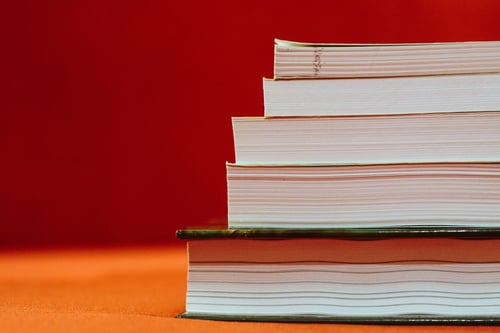 a stack of books on an orange surface