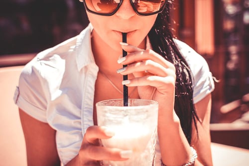 a woman drinking from a straw