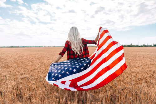 a woman holding a flag in a field