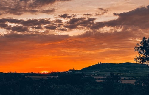 a sunset over a hill