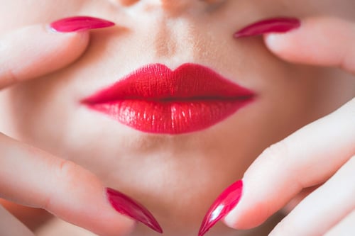 a close up of a woman's lips and nails