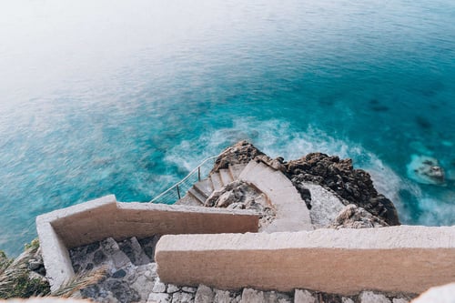a stairs on a rocky cliff by the ocean