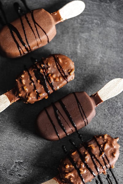 a group of chocolate covered ice cream on a stick