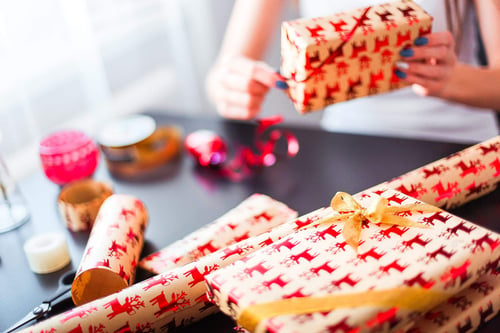 a person wrapping presents on a table
