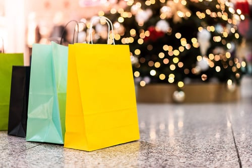 a group of shopping bags in front of a christmas tree