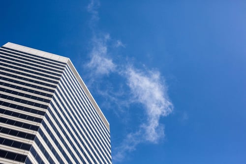 a tall building with clouds in the sky
