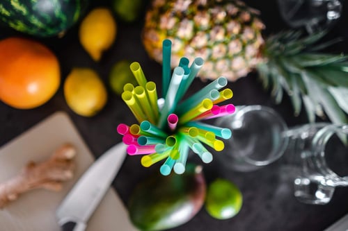 a group of colorful straws in a glass