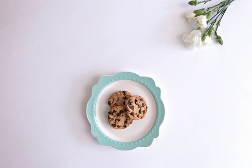 a plate with cookies on it and flowers