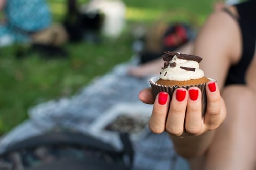 a hand holding a cupcake