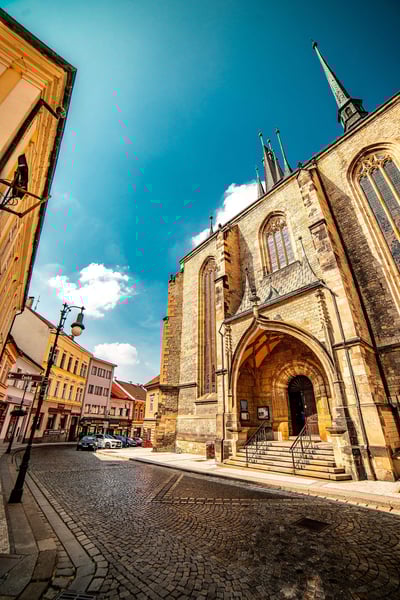 a stone building with a steeple and a street in the background