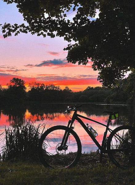 a bicycle parked on the shore of a lake