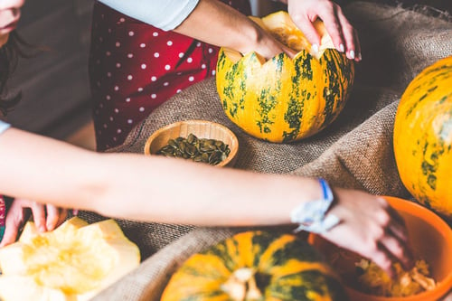 a person's hands cutting a pumpkin