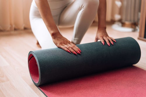 a person rolling a yoga mat