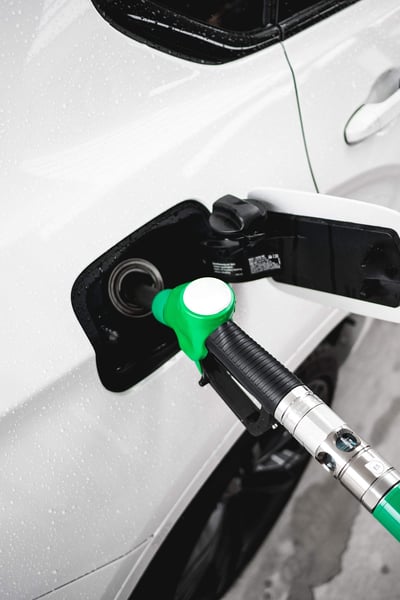 a green gas pump in a white car