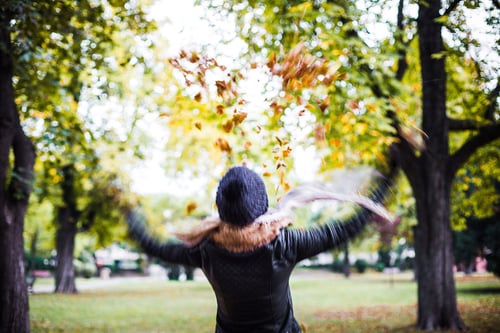 a woman throwing leaves in the air
