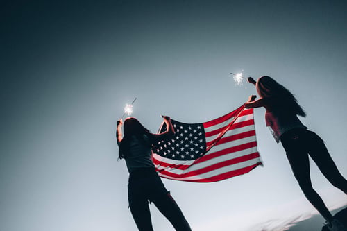 a group of people holding a flag and sparklers