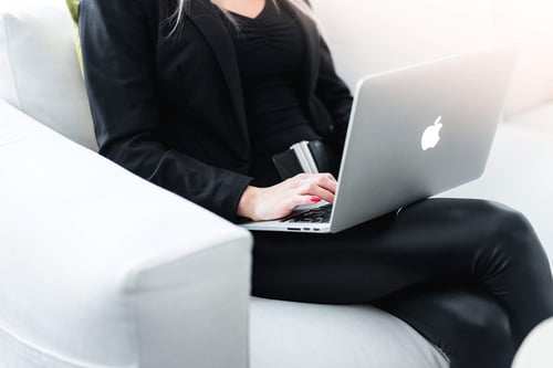 a woman sitting on a chair using a laptop