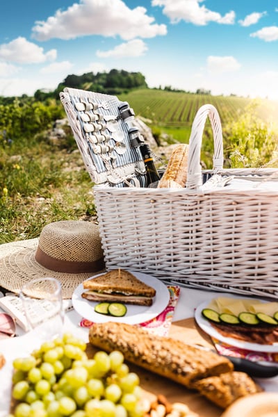 a picnic basket with food and wine on a table