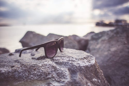 sunglasses on a rock by water