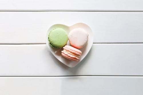 a plate of macaroons on a white surface