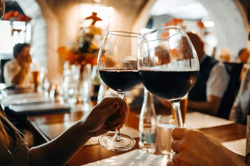 a couple of people clinking wine glasses