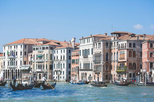 boats on a body of water next to buildings with Grand Canal in the background