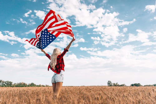 a woman holding a flag in a field