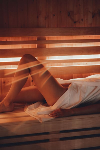 a person lying on a bench in a sauna