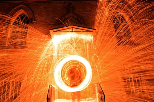 a person spinning fire in front of a building